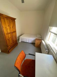 a bedroom with a bed and a desk and a chair at Ausis Accommodation Services in Melbourne