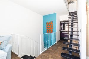 una escalera de caracol en una sala de estar con una pared azul en Sa Dommu e Mare, en Santa Maria Navarrese