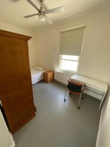 a bedroom with a desk and a bed and a window at Ausis Accommodation Services in Melbourne