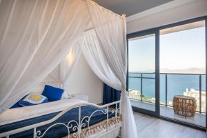 um quarto com uma cama de dossel e vista para o oceano em Argento Plazzo Family Apart Hotel em Bodrum City