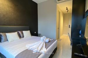 - une chambre avec un lit blanc et une robe dans l'établissement *12 (i) Axon Bukit Bintang KLCC 1 BED 1 BATH, à Kuala Lumpur