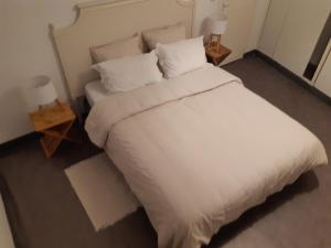 um quarto com uma grande cama branca e 2 candeeiros em Urban Chic 44 m2 em Brest