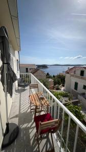 d'une table et de chaises sur un balcon avec vue sur l'océan. dans l'établissement Forr Apartments - Hvar, Croatia, à Hvar