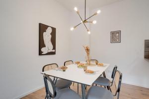 ein weißes Esszimmer mit einem weißen Tisch und Stühlen in der Unterkunft NEU-Luxus Apartment-Zentral 350m Altstadt-2Zi-65qm in Augsburg