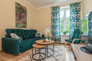 a living room with a green couch and a table at New apartment - Sunny & Quiet - 45m2 in Oświęcim