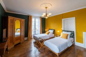 sypialnia z 2 łóżkami i żółtymi ścianami w obiekcie Villa du Loir w mieście La Flèche
