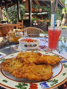 una mesa con un plato de comida y una bebida en Crama Haiducilor, en Cluj-Napoca