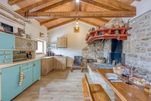 a kitchen with a table and a stone fireplace at Casa Fortunato with Private Pool in Pićan