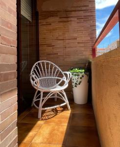 une chaise à bascule blanche assise sur une terrasse couverte dans l'établissement Vivienda con Parking incluido - Zona Van Dyck, à Salamanque