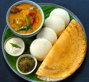 a plate of food with a bowl of soup and a plate of bread at Chaithritha Ladies Only Homestay in Trivandrum