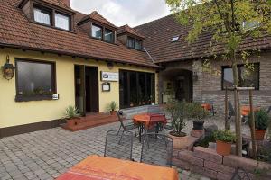 a house with a patio with a table and chairs at Hotel Am Markt in Kleinblittersdorf
