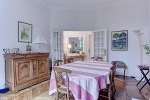 a dining room with a table and chairs and a kitchen at LE Saint Martin in Versailles