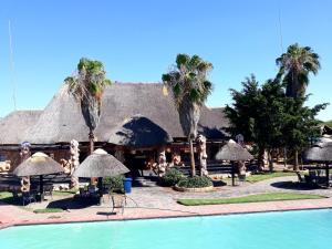 a resort with a swimming pool and palm trees at The Big Five Lodge in Gaborone