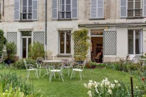 a garden with chairs and a table in front of a building at LE Saint Martin in Versailles