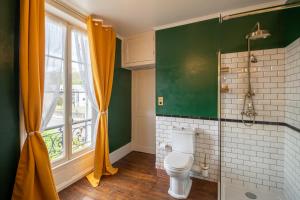 een badkamer met een toilet en een raam bij Villa du Loir in La Flèche