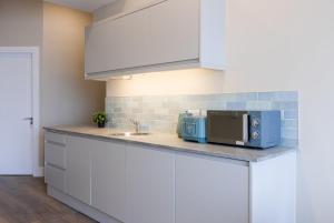uma cozinha com um balcão com um micro-ondas e um lavatório em GuestReady - Dublin 8 Delight Retreat em Dublin