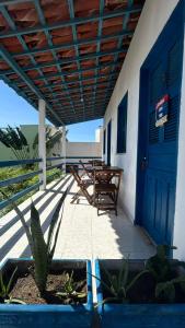 een veranda met een blauwe deur en houten banken bij Pousada Capitolio 01 - Canoa Quebrada - hospedagem in Canoa Quebrada