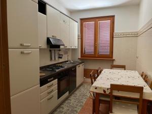 cocina con mesa y cocina con fogones en Villa Alba en Fermo