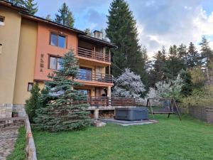 a large house with a large yard with a tree at Guest house Lidia in Tsigov Chark