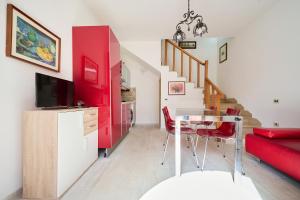 ein Wohnzimmer mit einem Tisch und einem roten Sofa in der Unterkunft Trilocale San Luigi a San Vincenzo in San Vincenzo