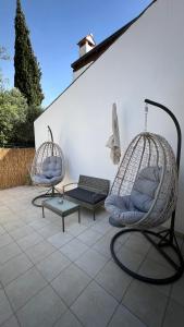 two swing chairs and a bench on a patio at Forr Apartments - Hvar, Croatia in Hvar