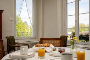 拉弗累什的住宿－Villa du Loir，一间带桌子和2个窗户的用餐室