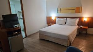 um quarto de hotel com uma cama e uma televisão de ecrã plano em Hotel Live Logde Vila Mariana Pq Ibirapuera UH-511 em São Paulo