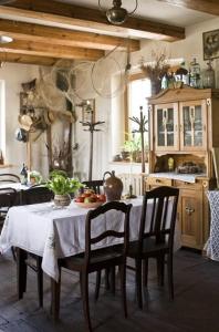 jadalnia ze stołem i krzesłami oraz kuchnia w obiekcie Karczma Stary Młyn w mieście Giżycko