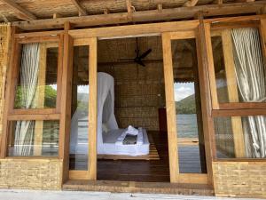 a room with a bed on a deck with windows at Floating Paradise in Karimunjawa