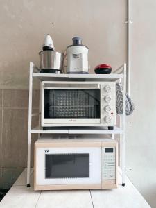 a microwave oven sitting on top of a white cart at Imogen Yogyakarta in Yogyakarta