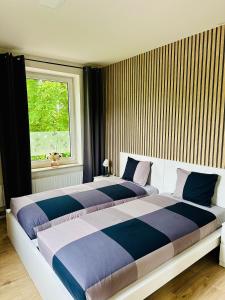 2 łóżka w sypialni z oknem w obiekcie Apartmány LUXOR w mieście Česká Lípa