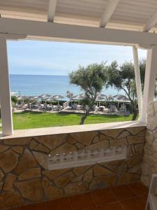 uma janela com vista para o oceano a partir de um resort em Hamre Apartments (Nicholas) em Agios Georgios Pagon