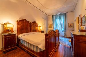 Un dormitorio con una gran cama de madera y una ventana en Villa Lucia a Laglio by Wonderful Italy en Laglio