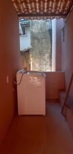 a small refrigerator in a room with a window at Casa na praia em frente as Dunas in Salvador