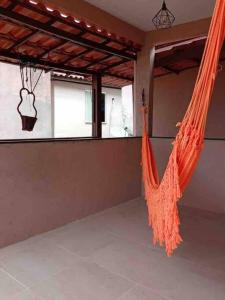 an empty room with an orange hammock in a room at Casa na praia em frente as Dunas in Salvador