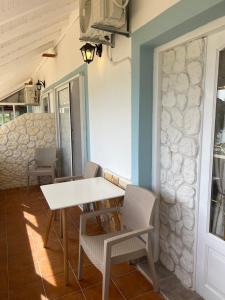 uma sala de jantar com uma mesa branca e cadeiras em Hamre Apartments (Nicholas) em Agios Georgios Pagon