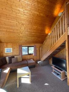 a living room with a couch and a staircase in a cabin at 3 Bedroom Lodge Lanteglos 17 in Lanteglos