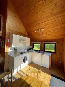 uma cozinha num chalé de madeira com um tecto de madeira em 3 Bedroom Lodge Lanteglos 11 em Lanteglos