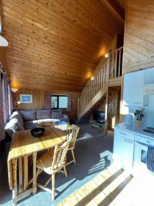 uma cabina de madeira com uma mesa e um sofá em 3 Bedroom Lodge Lanteglos 11 em Lanteglos