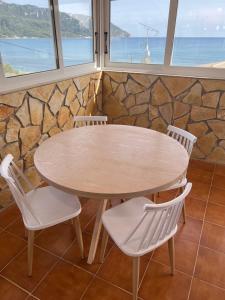 uma mesa e cadeiras num quarto com vista para o oceano em Hamre Apartments (Nicholas) em Agios Georgios Pagon