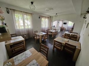 a dining room with tables and chairs and windows at Uptown Inn in Sarajevo