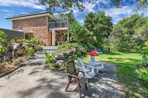 a patio with two chairs and a house at Riverfront Oasis in Elanora in Gold Coast