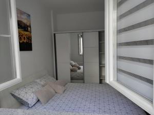 a small bedroom with a bed and a mirror at Nevena in Trebinje