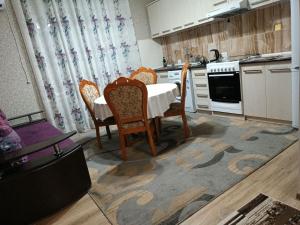 a kitchen with a table and chairs in a kitchen at Oskar in Toktogul