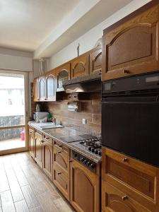 uma cozinha com armários de madeira e um forno com placa de fogão em Apartment in town centre and nearby the lake em Riva del Garda