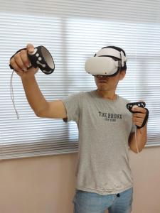 礁溪鄉的住宿－木Box田妍山色，戴虚拟现实头盔的男子,手持两台控制器