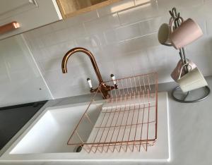a kitchen sink with a copper faucet and a lamp at Caledonian lodges 2 Inverness in Inverness