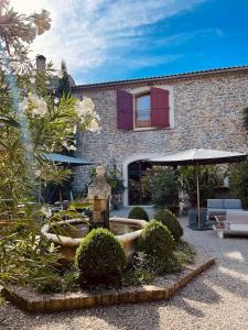 un giardino con fontana di fronte a un edificio di Grande Maison de Charme a 5 mn du centre ville a Narbonne