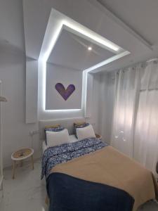 um quarto com uma cama com uma pintura de coração na parede em Casa estilo Riad Fez en Lo Pagan em San Pedro del Pinatar