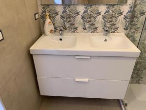 bagno con lavandino bianco e specchio di Casa vacanze Marubium a Maruggio